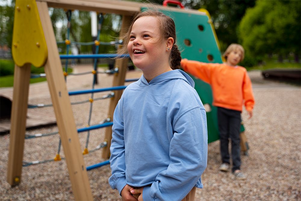 Aluna do ensino fundamental com síndrome de Down brincando no parque com com os colegas de classe.