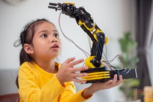 menina segurando um braço robótico.